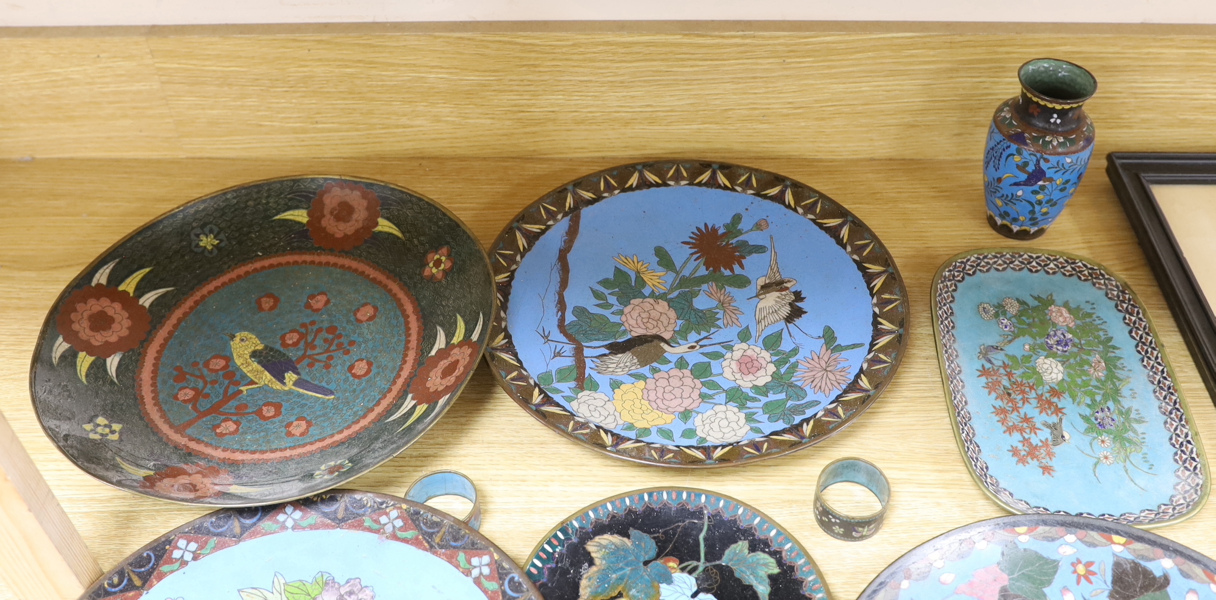 Collection of Japanese cloisonné enamel plates, napkin rings and a vase, each enamelled with birds and flowers, the largest 29cm in diameter